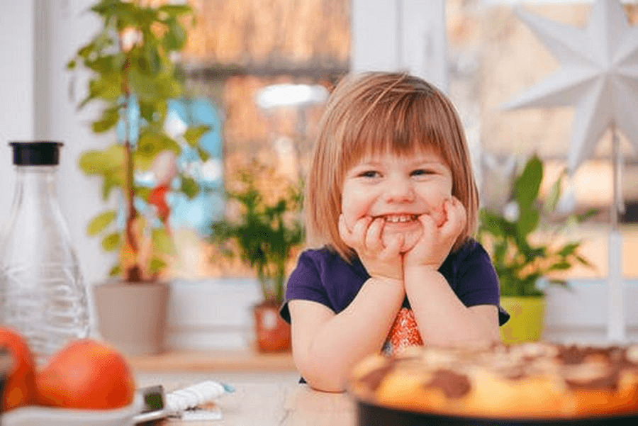 Dziecko z uśmiechem przygryzające palce – typy tyłozgryzu